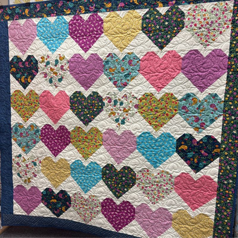 Quilt with colorful heart patterns on a white background
