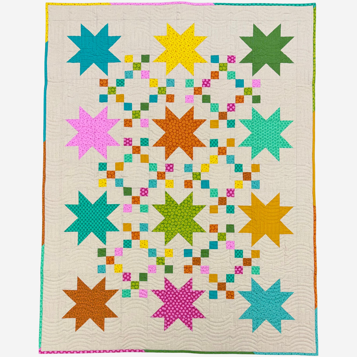 A quilt featuring a geometric star pattern with alternating large eight-pointed stars in teal, yellow, green, pink, orange, and aqua on an off-white background, surrounded by a multicolored binding.
