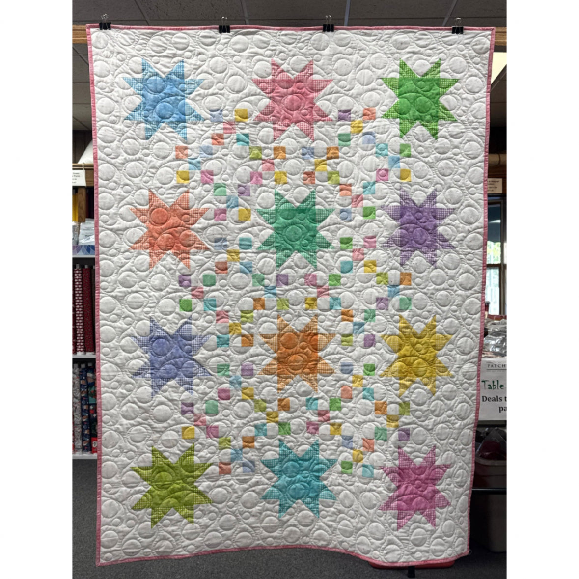 Colorful star-patterned quilt on a white background