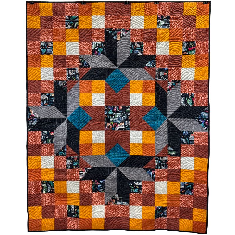 Quilt with a geometric pattern featuring squares in various colors on a white background