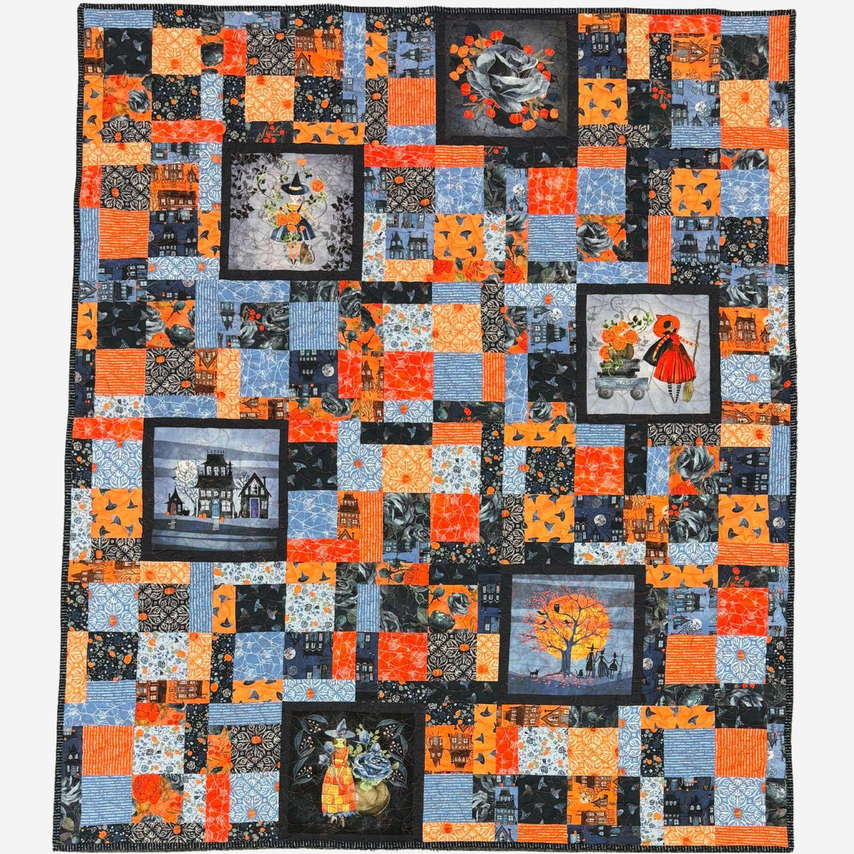 A square patchwork quilt featuring a Halloween theme, composed of various orange, blue, black, and gray patterned fabrics with printed illustrations of haunted houses, witches, pumpkins, and autumn trees.